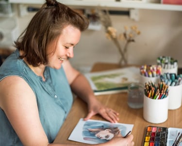 Sabrina zeichnet ein Portrait und lächelt