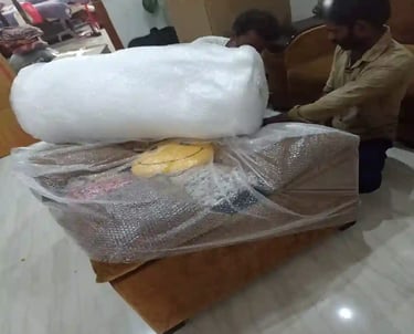 Seemanchal Packers & Movers staff carefully packing a sofa with bubble wrap and protective materials