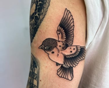 a bird tattoo on the arm of a man's arm