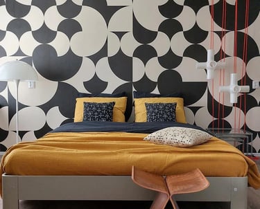 a bed with a yellow bed and a red rug designed by house of akaya India