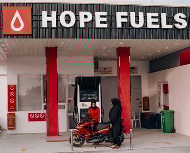 a sales associate refilling gas a motorcycle from a dispenser