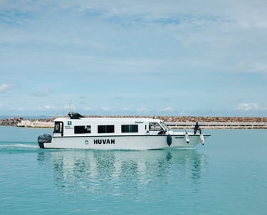 a boat with a man standing on the front area of the boat