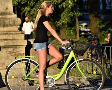 a woman riding a green bicycle with a bicycle basket