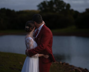 Des mariés s'embrassant au bord d'un lac au crépuscule lors d'un mariage