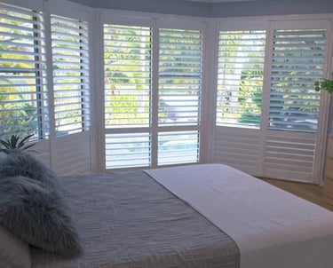 Bay window shutters fitted in a bedroom