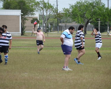 a group of men playing a game of rugby shirtless