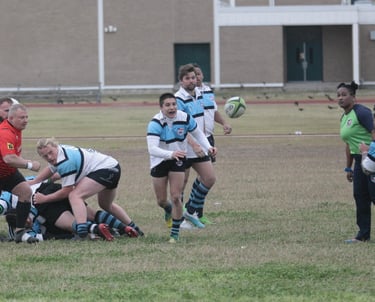 a group of men playing rugby in a field passing scrum half