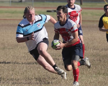 a man in a white shirt is playing rugby making a big tackle on texas teams