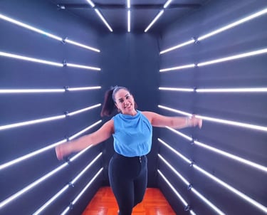 a woman in a blue top and black leggings and a blue top in a led backdrop tunnel