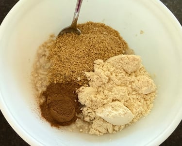 Oatmeal ingredients including protein powder, flaxseed, and cinnamon in a bowl.