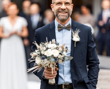 Un homme en costume avec un bouquet de fleurs à la main