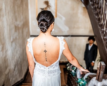 Une femme en robe de mariée dans les escaliers regardant son futur mari