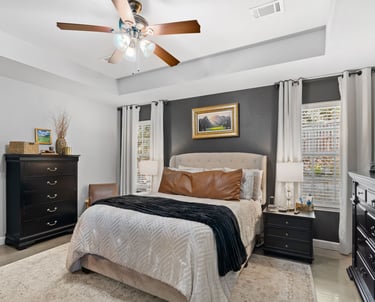 a bedroom with a bed and a ceiling fan