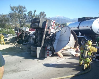a firefighter standing next to a truck with a hose attached to it