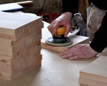 Mann schleift Bretter aus massivem Eichenholz ab