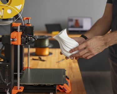 Mann nimmt eine 3D-gedruckte Vase aus dem 3D-Drucker