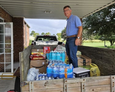 Man standing on a trailer with donations for western NC hurricane relief