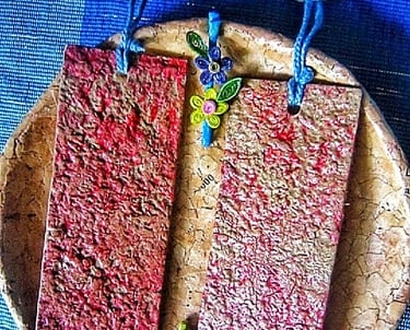 Recycle paper plain red texture of bookmark with two pieces of recycle paper mini hair clips on the recycle paper plate 