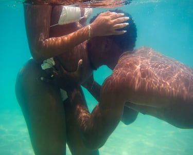 un homme embrasse sa femme enceinte sous l'eau