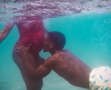 un homme embrasse sa femme enceinte sous l'eau