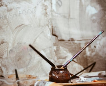 image of an artist's workbench with paint and paintbrushes