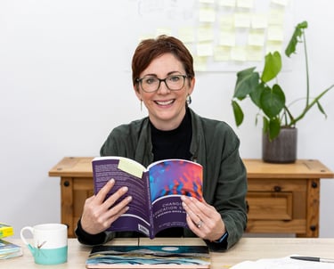 a woman is smiling and holding a book