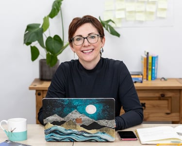 a woman sitting at a desk with a laptop computer
