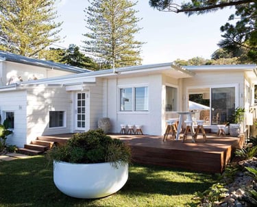 a house with a large white planter and a large white potted planter