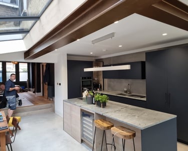Modern kitchen in Balham with exposed beams and black cabinets, interior painting by Pure Perfection