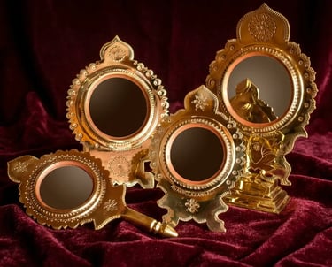 Handcrafted Aranmula Kannadi metal mirrors with ornate gold brass frames on a red velvet background.