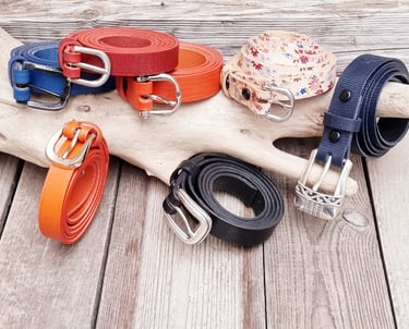 un tas de ceintures et de courroies sur une table en bois