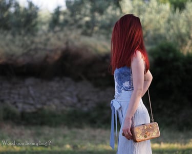 a woman in nature with elegant wooden clutch
