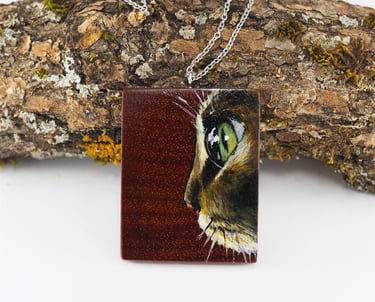 hand painted image of a cat on padouk wood pendant