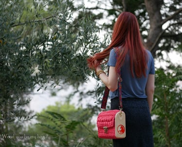 a woman with crocheted pink wooden crossbody bag with horse image