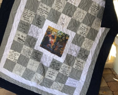 Bride and groom holding their finished signature quilt guest book