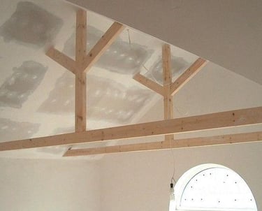 Gerenoveerd oud plafond van gipsplaten met zichtbare balken.