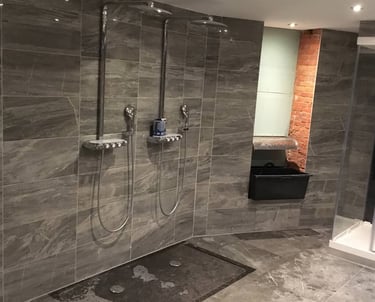 Badkamer met grijze tegels en zwart inloopdouche 