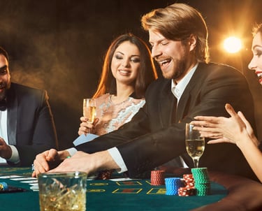 Cilvēki ballītē ar dzērieniem spēlē kāršu spēli uz kazino galdiņa