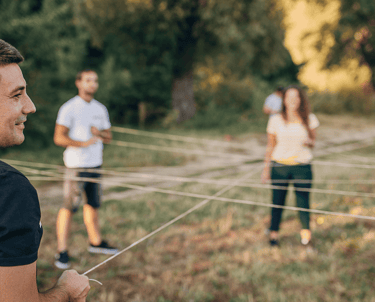 Komanda spēlē spēli ārtelpās ar striķi