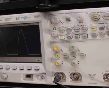 An oscilloscope being used to calibrate a camera PCB