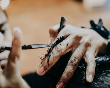 a man is getting his hair cut and styled by a woman