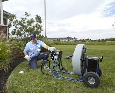 A man in a blue shirt is holding a hose