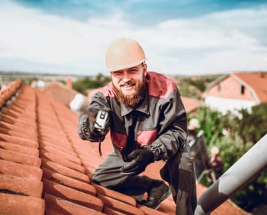 roofing worker smiling for the camera on an orange roof
