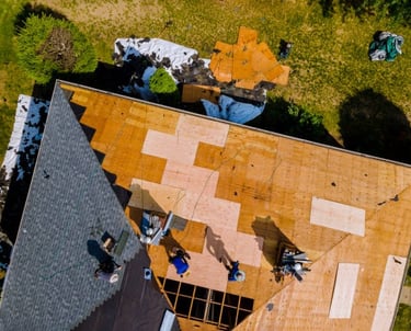 sky view of construction workers installing roof tiles