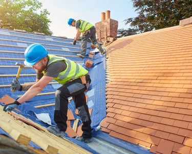 2 roofing workers installing orange tiles