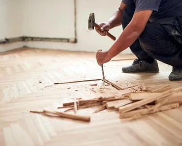 ouvrier qui casse du parquet au sol