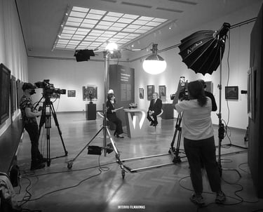 Profesionali filmavimo komanda, naudodama vaizdo kameras ir studijinį apšvietimą, filmuoja interviu.