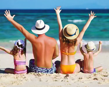 a family of four children sitting on a beach