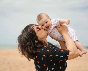 Mother kissing a baby on Brighton Beach