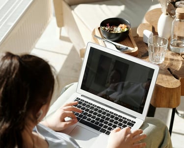 a woman sitting on a couch with a laptop